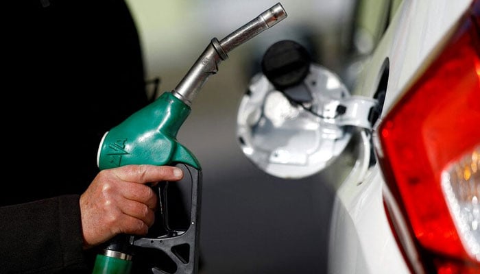 A man holds a fuel nozzle at a petrol station in Reze, near Nantes, France, March 18, 2022. —Reuters