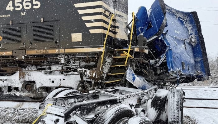 This handout image released by the Gastonia Police Department shows a semi-truck struck by a freight train at the intersection of Poplar Street and Airline Avenue in Gastonia, north of downtown Charlotte, North Carolina, on January 31, 2026, amid a winter snowstorm affecting the region. — AFP