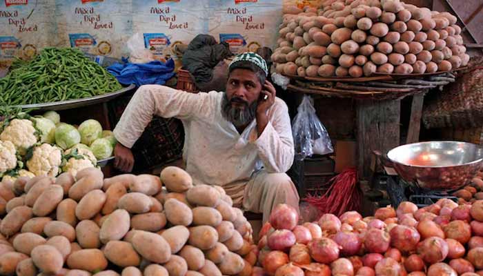A man selling vegetables waits for customers at his makeshift stall at the Empress Market in Karachi. — Reuters/File