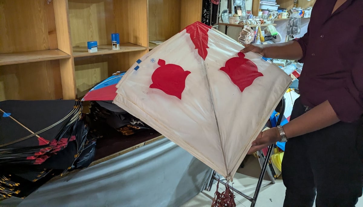 A shopkeeper holds a kite in his hands. — Photo by Geo.tv