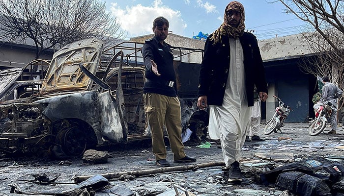 A police officer and a person stand amid damages at a police station, following militant attacks, in Quetta, Pakistan, February 1, 2026. — Reuters