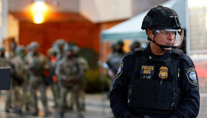 A Federal Protective Service police officer guards the gate of a ICE facility in Portland, Oregon, US on October 26, 2025. — Reuters