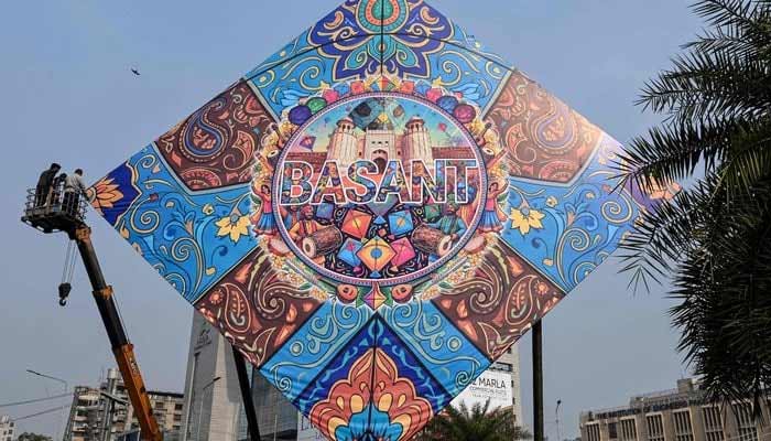 Workers install a large model of a kite celebrating the Basant festival in Lahore on February 3, 2026. — Reuters
