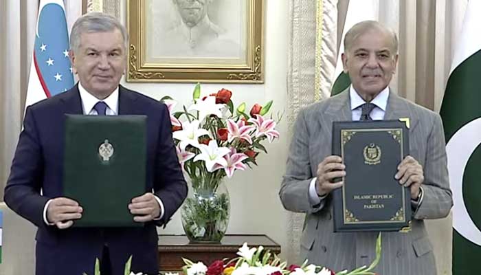 Uzbekistan President Shavkat Mirziyoyev (left) and Prime Minister Shehbaz Sharif exchange documents as both sides ink multiple agreements and MoUs during ceremony at PMs House on February 5, 2026. — Screengrab via Geo News