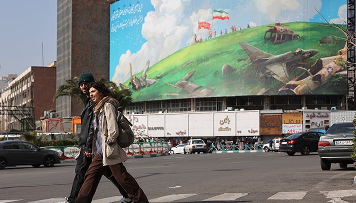 People walk past an anti-US billboard on a street in Tehran, Iran, February 5, 2026. — Reuters