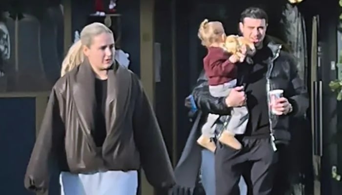 Molly concealed her baby bump in a black coat while battling wind with Tommy