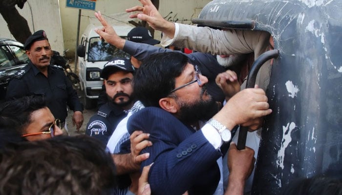 Police take JI workers into to custody from outside ECP office in Karachi on February 8, 2026. — JI