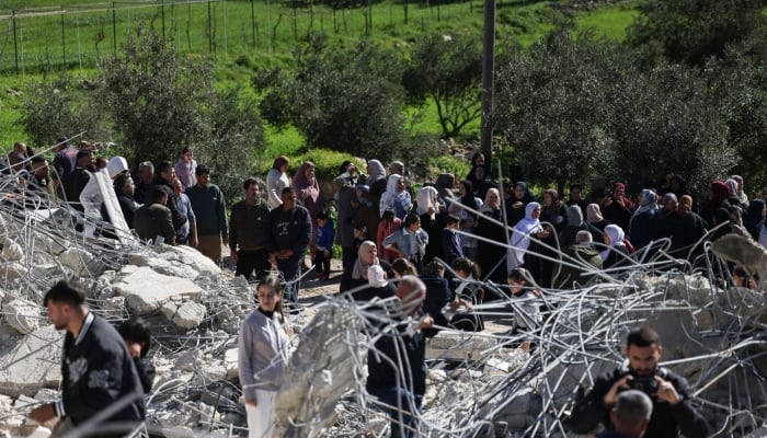 Palestinians gather to look at the concrete and steel debris from homes and shops after bulldozers protected by Israeli security forces demolished residential buildings belonging to Palestinian families in Beit Aawa in occupied West Bank, February 5, 2026. — AFP