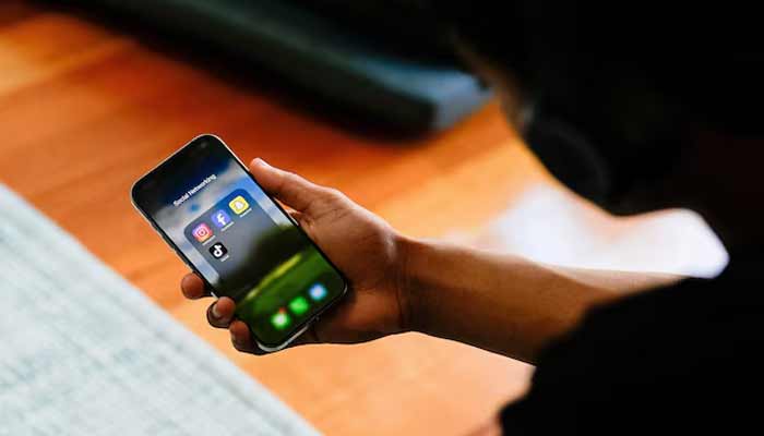 A high school student poses with his mobile phone showing his social media applications in Melbourne, Australia, November 28, 2024.— Reuters/File