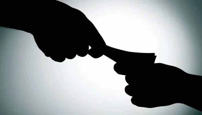 The representational image shows money being exchanged as bribery. — AFP/File