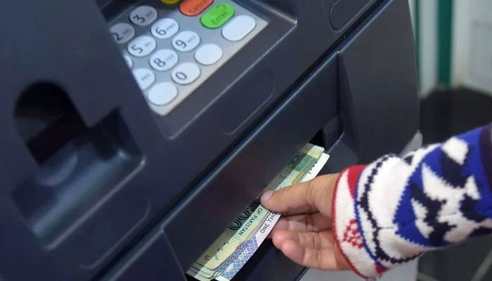 A person withdrawing cash from an Automated Teller Machine. — AFP/File