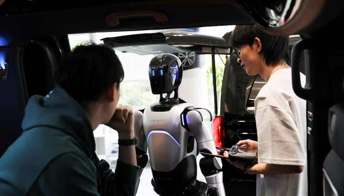 Employees demonstrate an AgiBot humanoid robot at a China Yongda Automobiles Services Holdings Ltd. car dealership, in Shanghai, China. — Reuters/File