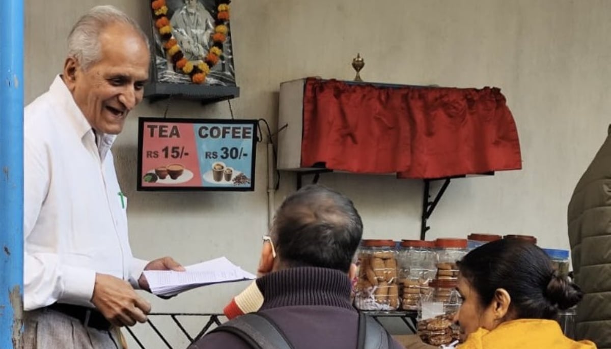 Prof Tripathi hands over flyers to people. — X/@rakhitripathi