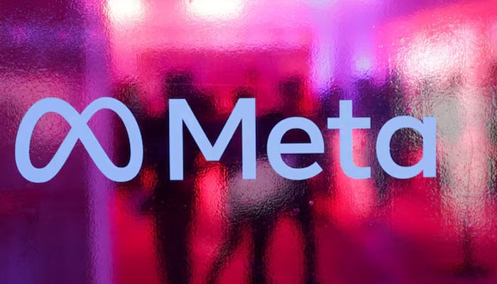 People walk behind a logo of Meta Platforms company, during a conference in Mumbai, India, September 20, 2023. — Reuters