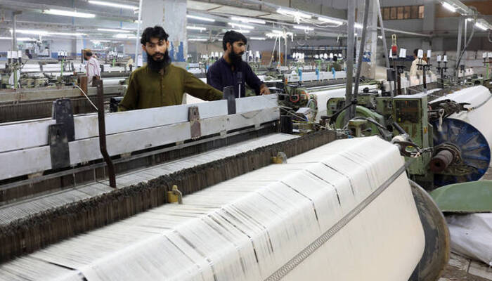 Economy Workers inspect loom machines, weaving fabric at a textiles manufacturer in Karachi on April 3, 2025. — Reuters