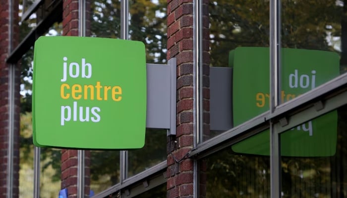 People walk alongside a Job Centre Plus in London, Britain, October 25, 2023. — Reuters