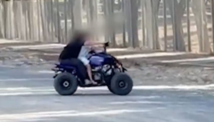 Screenshot taken from video released by Dubai police on February 20, 2026, showing two children riding a recreational electric motorbike on a public street in Dubai. — X@DubaiPoliceHQ