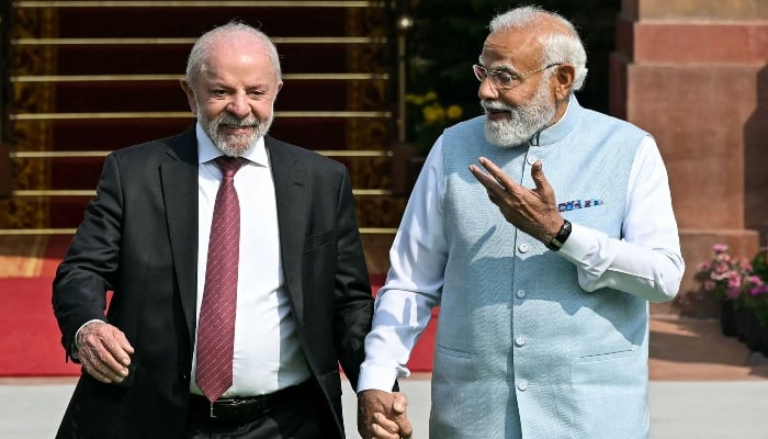 Indias Prime Minister Narendra Modi (right) holds hands with Brazils President Luiz Inacio Lula da Silva as they walk before their meeting at the Hyderabad House in New Delhi on February 21, 2026. — AFP