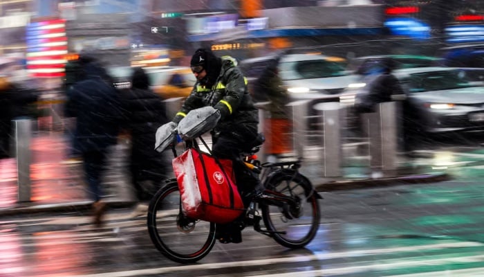 Powerful winter storm shuts schools, disrupts travel across US Northeast 11 A delivery worker rides his bicycle around Times Square as snow falls during a winter storm in New York City, US, February 22, 2026. — Reuters