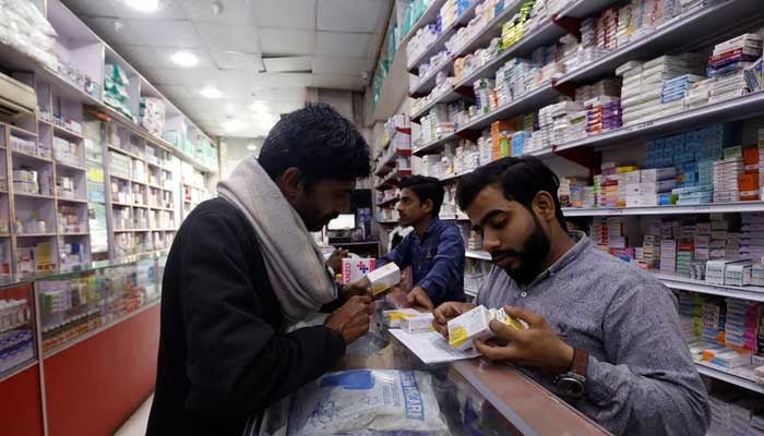 A customer buys medicine from a medical supply store in Karachi on February 9, 2023. — Reuters