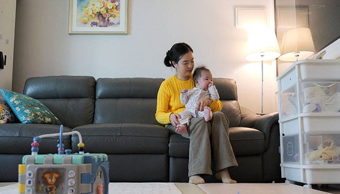 Nam Hyun-jin takes care of her baby at her home in Seoul, South Korea on February 17, 2025. — Reuters
