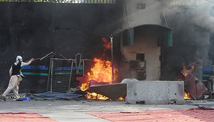A protester sets fire near a gate leading to the US Consulate during a violent protest against the US and Israels attack on Iran, in Lahore, Pakistan, March 1, 2026. — Reuters