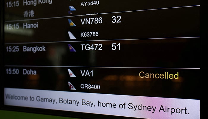 A departures board displays a cancelled sign next to a flight to Doha, at Sydney Airport in Sydney, Australia, March 2, 2026. — Reuters