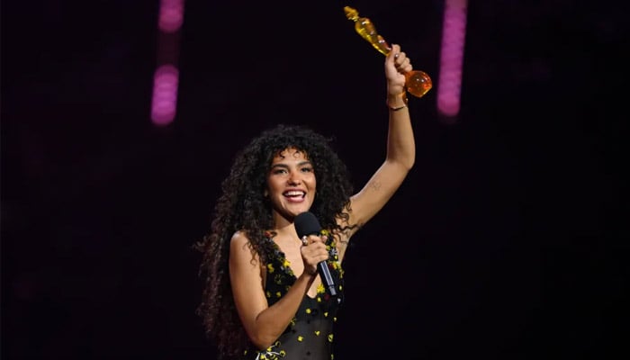 Olivia Dean flexes four BRITs trophies in inspiring message