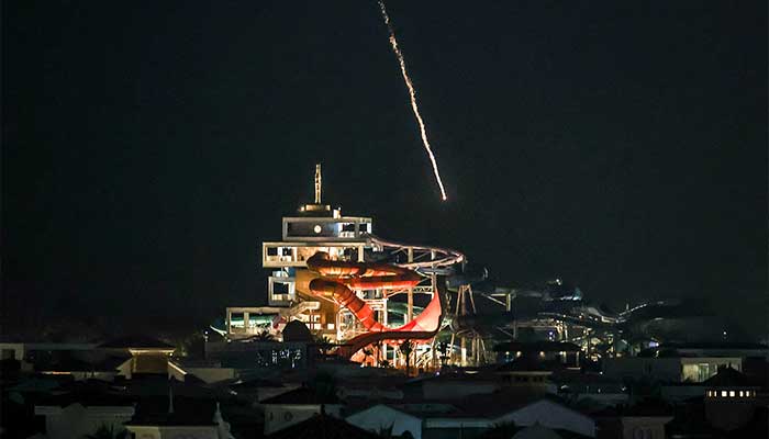 An intercepted projectile falls into the sea near Dubais Palm Jumeirah archipelago on March 1, 2026. — AFP