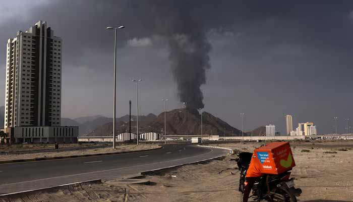 A person stands next to a motorcycle as smoke rises in the Fujairah oil industry zone following a fire caused by debris after interception of a drone by air defenses, according to the Fujairah media office, amid the US-Israel conflict with Iran, in Fujairah, United Arab Emirates, March 3, 2026.— Reuters/File