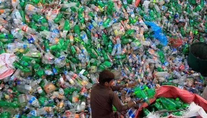 An image showing a boy collecting scrap plastic bottles. — Reuters/File