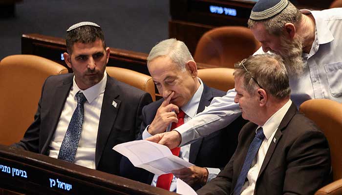 Israeli Prime Minister Benjamin Netanyahu holds a document at the plenum of the Knesset, Israels parliament in Jerusalem February 23, 2026. — Reuters