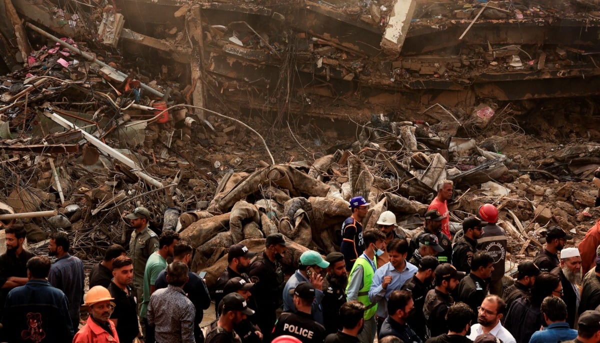 Police officers, rescue workers and shopkeepers gather, following a massive fire that broke out in the Gul Plaza Shopping Mall in Karachi on January 19, 2026. — Reuters