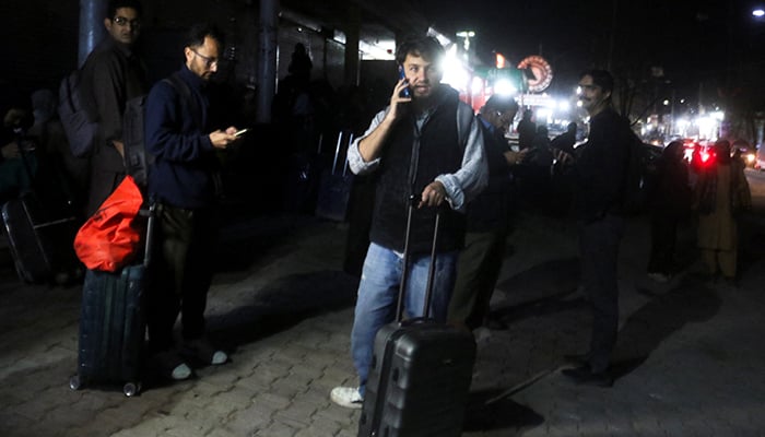 Noman Ali, 26, a Pakistani student, uses a mobile phone as he stands with his belongings after returning from Iran following the US and Israeli strikes, in Quetta, March 3, 2026. — Reuters