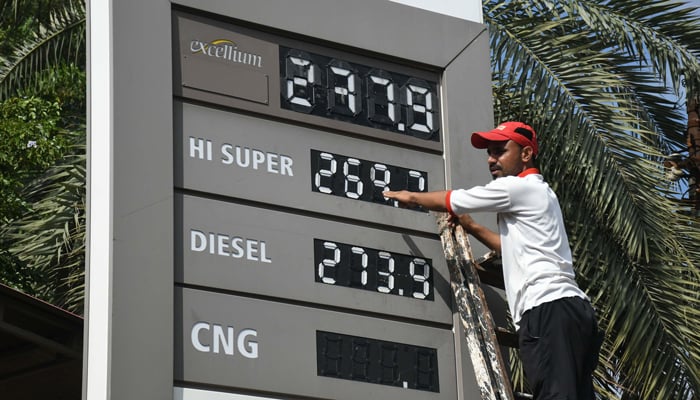 An employee of a petrol station updates the latest fuel prices on the board in Karachi, on October 1, 2025. — Online