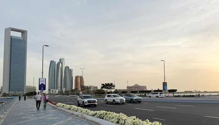 People walk on a promenade overlooking the skyline in Abu Dhabi, United Arab Emirates. — Reuters/File