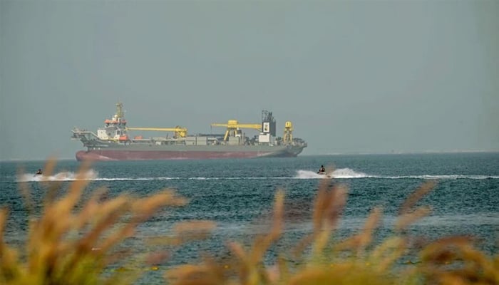 Bathers ride jet skis past anchored commercial vessels off the coast of Dubai, United Arab Emirates, March 2, 2026. — AFP