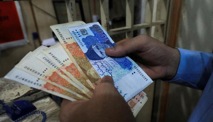A man counts Pakistani rupee notes at a currency exchange shop in Peshawar, Pakistan September 12, 2023. — Reuters