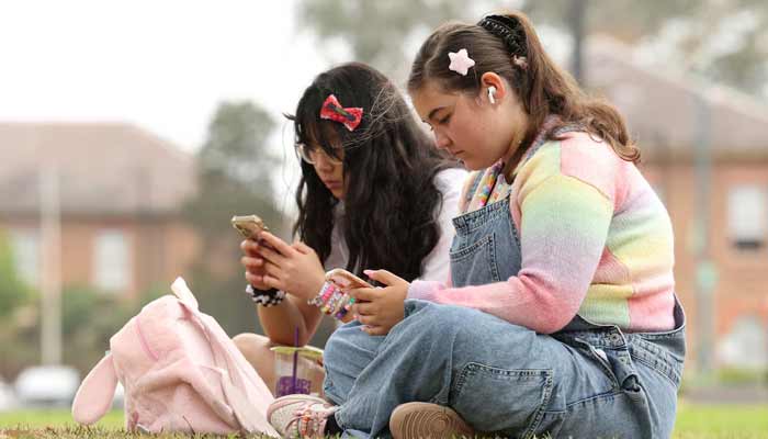 Teen use their mobile phones, ahead of Australia’s social media ban for users under 16. — Reuters/File