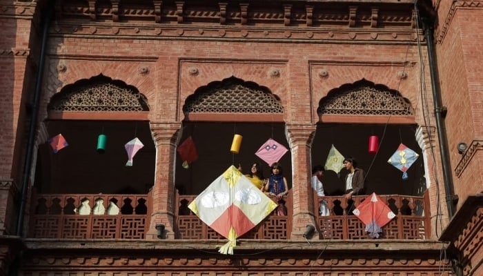 People stand with kites on display to mark Basant, a kite-flying festival, in Lahore on February 6, 2026. —