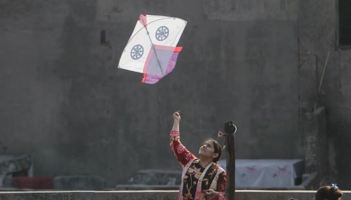 A woman flies a kite from a rooftop to mark Basant, a kite-flying festival, in Lahore on February 6, 2026. — Reuters