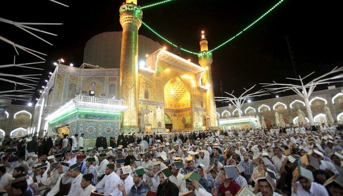 Muslims place copies of the Quran on their heads during Ramadan at the Imam Ali Shrine, Najaf, Iraq July 10, 2015. — Reuters
