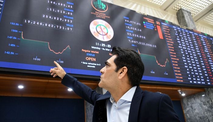 An investor monitors a digital board showing share prices at the Pakistan Stock Exchange (PSX) in Karachi on March 9, 2026. — Online