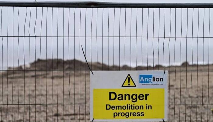 A warning sign is seen near the beach in a coastal town.