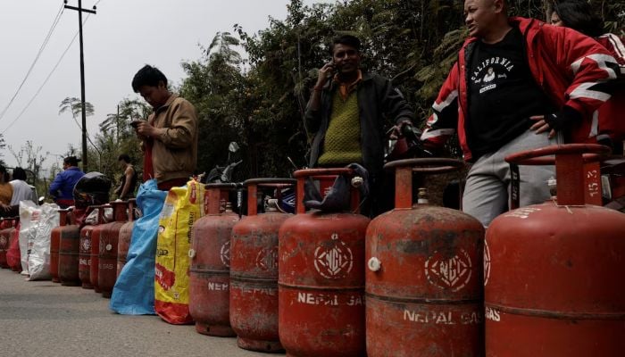 People stand in a queue with their empty LPG cylinders outside a depot of Nepal Gas Industries Pvt. Ltd. amid the US-Israeli conflict with Iran, in Kathmandu, Nepal, March 12, 2026. — Reuters