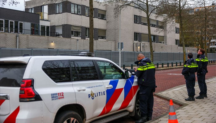 Police officers stand outside a Jewish school following an explosion that caused minor damages, in Amsterdam, Netherlands, March 14, 2026. — Reuters