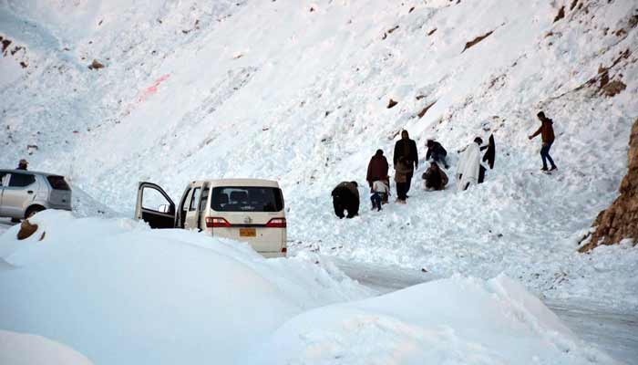 People enjoy snowfall in the Hanna Orak area of Quetta. — APP/File