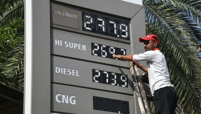 An employee of a petrol station updates the latest fuel prices on the board in Karachi, on October 1, 2025. — Online