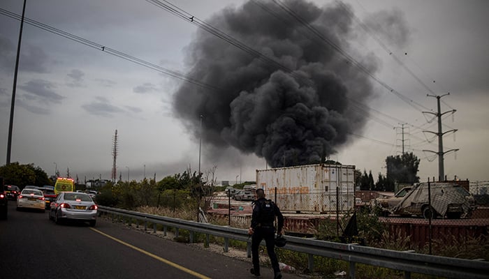 A policeman runs to an impact site following an Iranian missile strike, amid the US-Israeli war with Iran, in central Israel, March 13, 2026. — Reuters