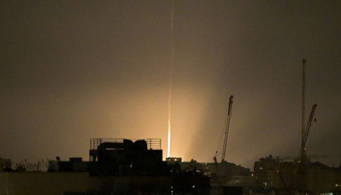 The sky is illuminated as an Iranian missile lands in Israel, amid the US-Israeli conflict with Iran, as seen from Tel Aviv, Israel, March 12, 2026. — Reuters